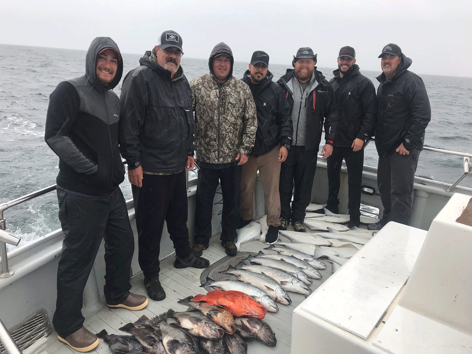 Six men on Alaskan fishing boat with their catches