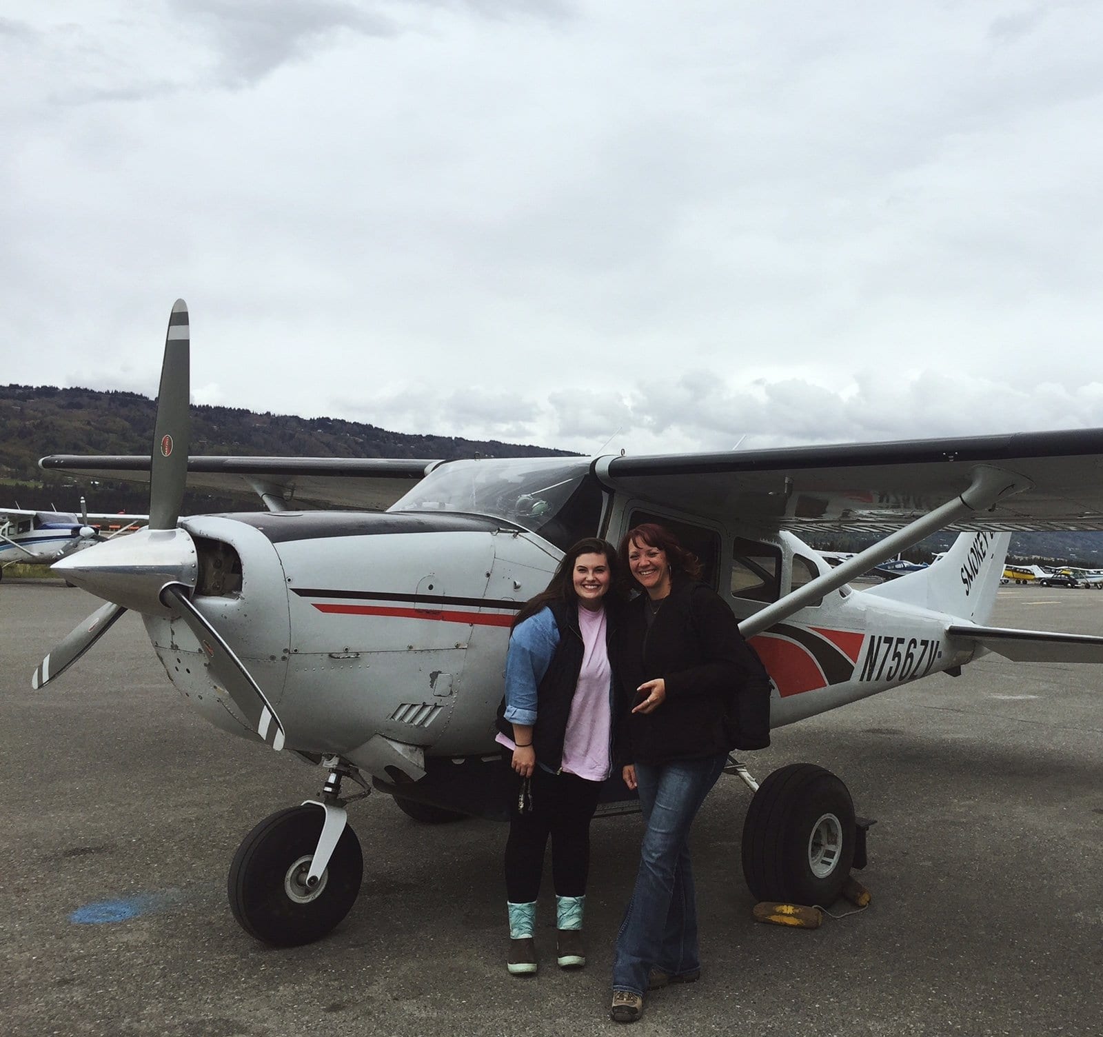 two women standing in front of plane