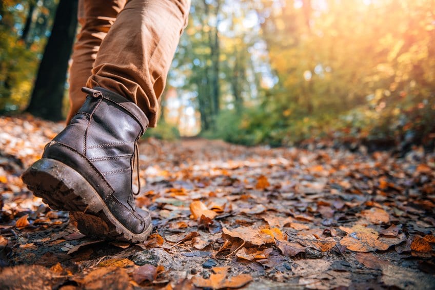 close up of hiking boots on trail in autumn