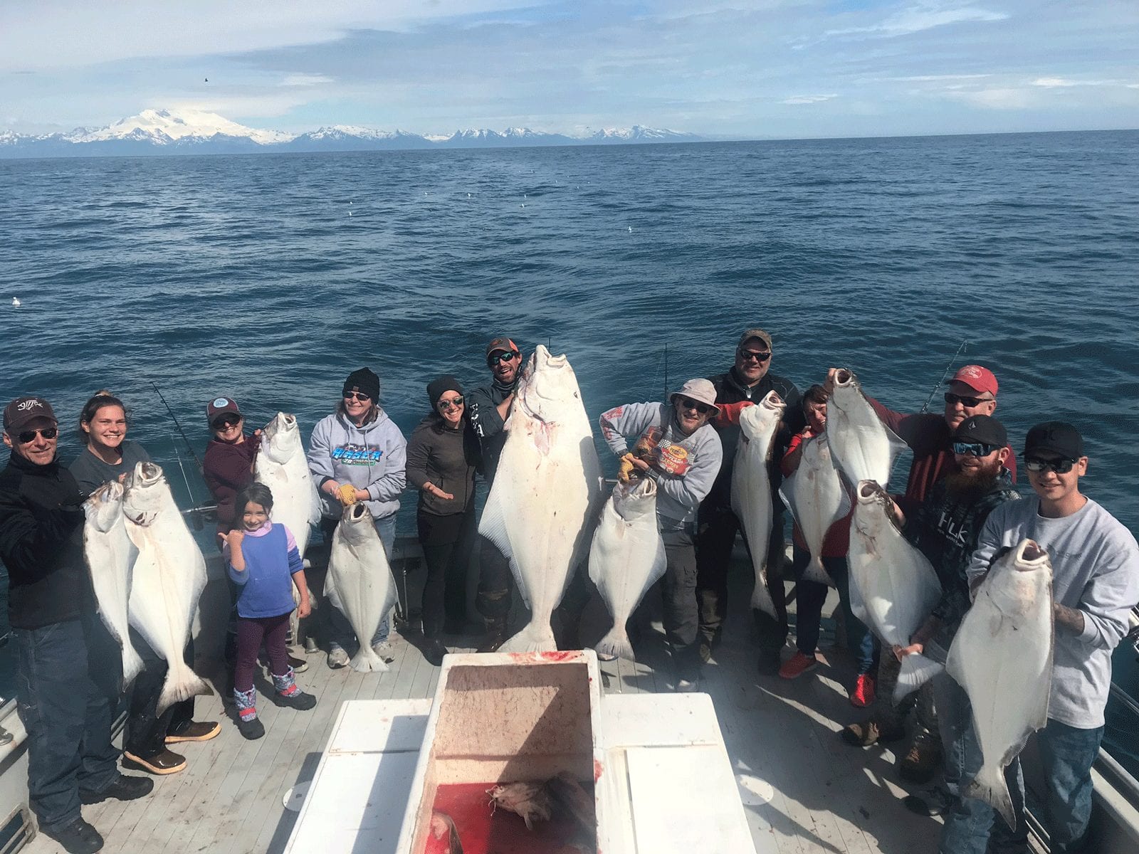 people on boat holding large fish