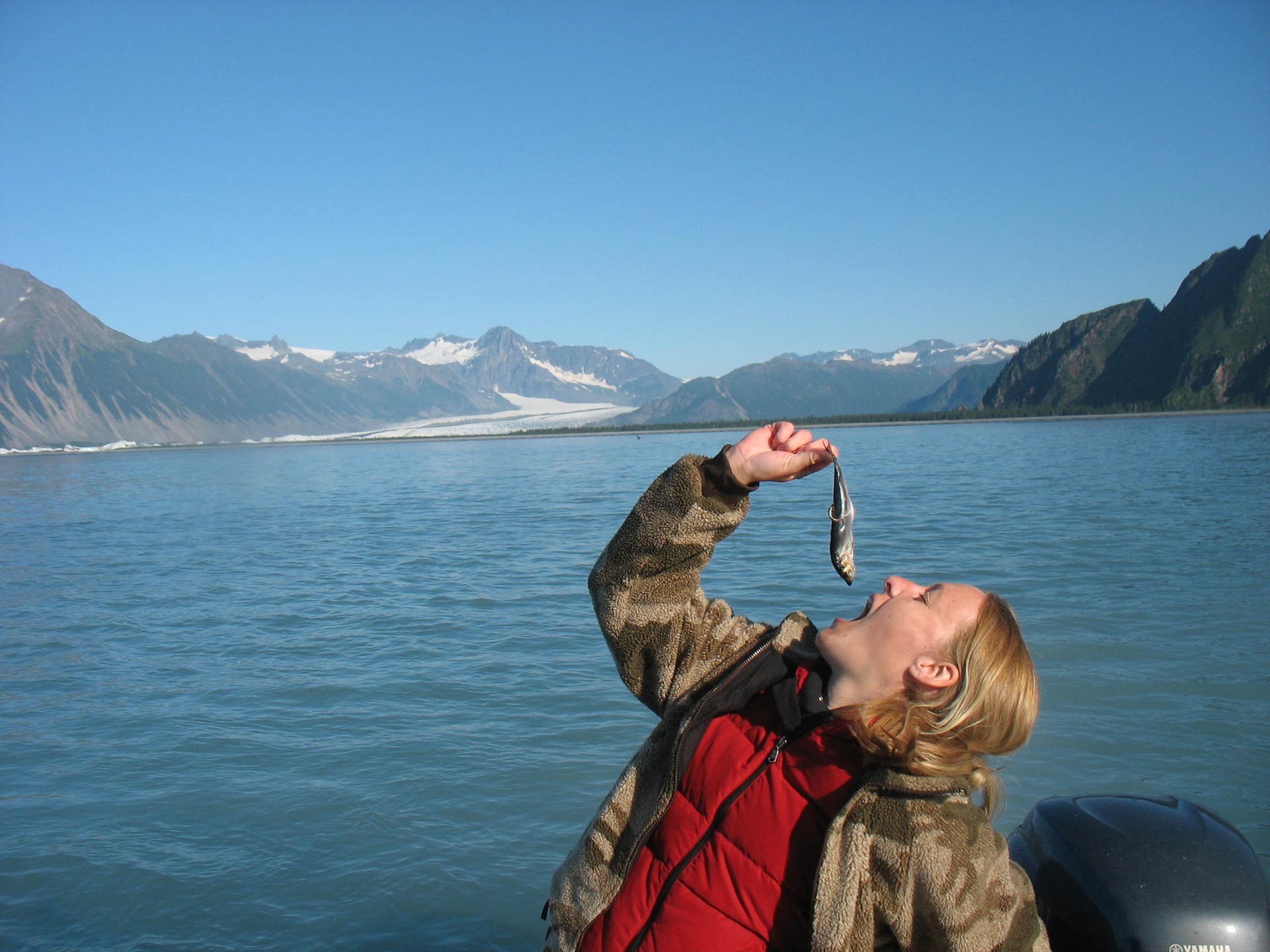 woman appearing to put small fish in his mouth