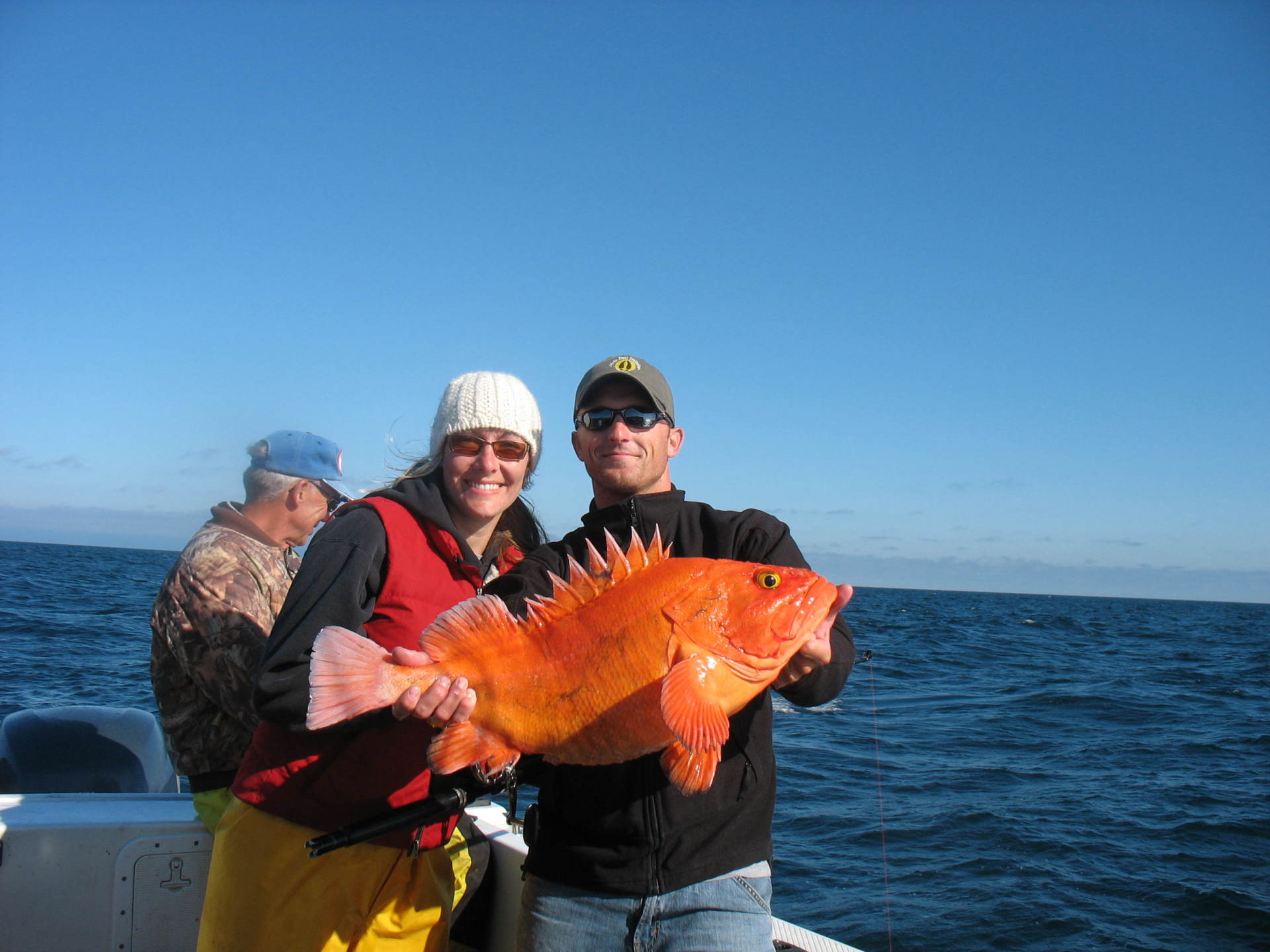 couple holding large orange fish