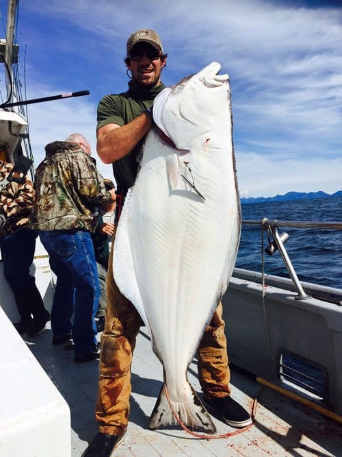 man holding Alaskan halibut