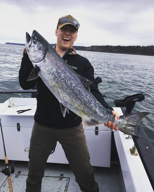 man holding large king salmon
