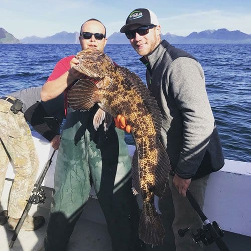 two men holding a large rockfish