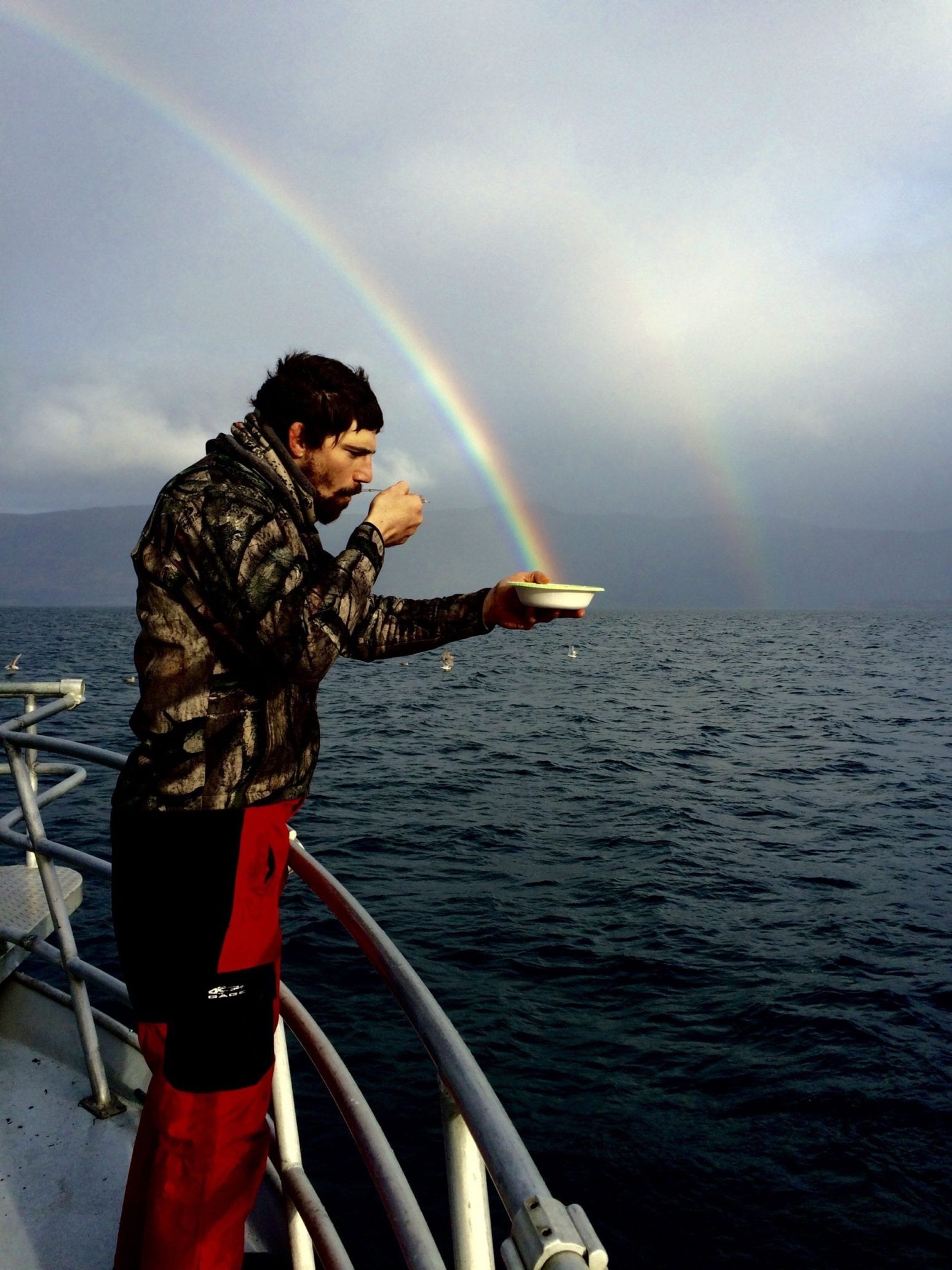 man eating cereal with rainbows in background