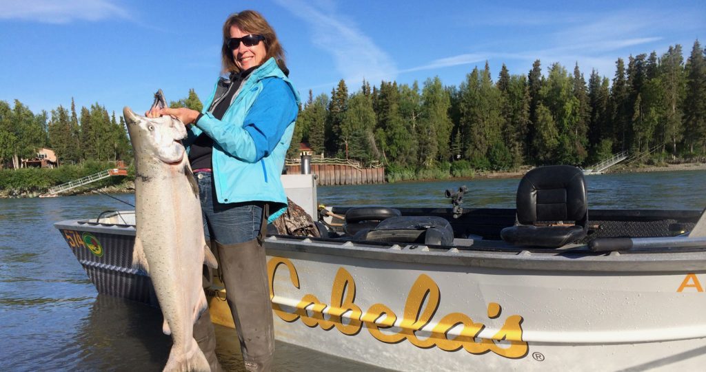 woman holding huge chinook salmon after fishing kenai peninsula