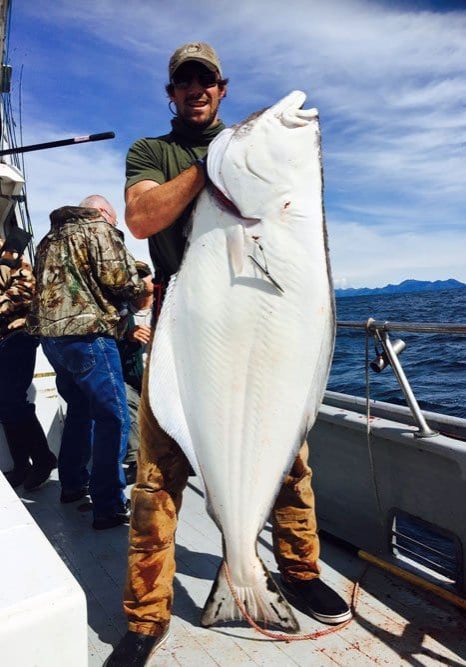 man holding Alaskan halibut
