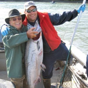 two men holding large salmon