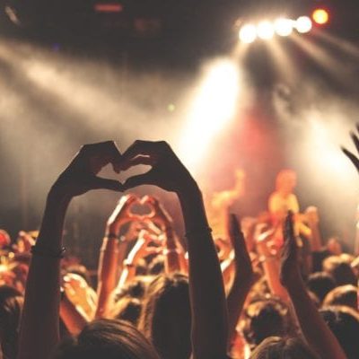 hands up in heart shape at crowded concert