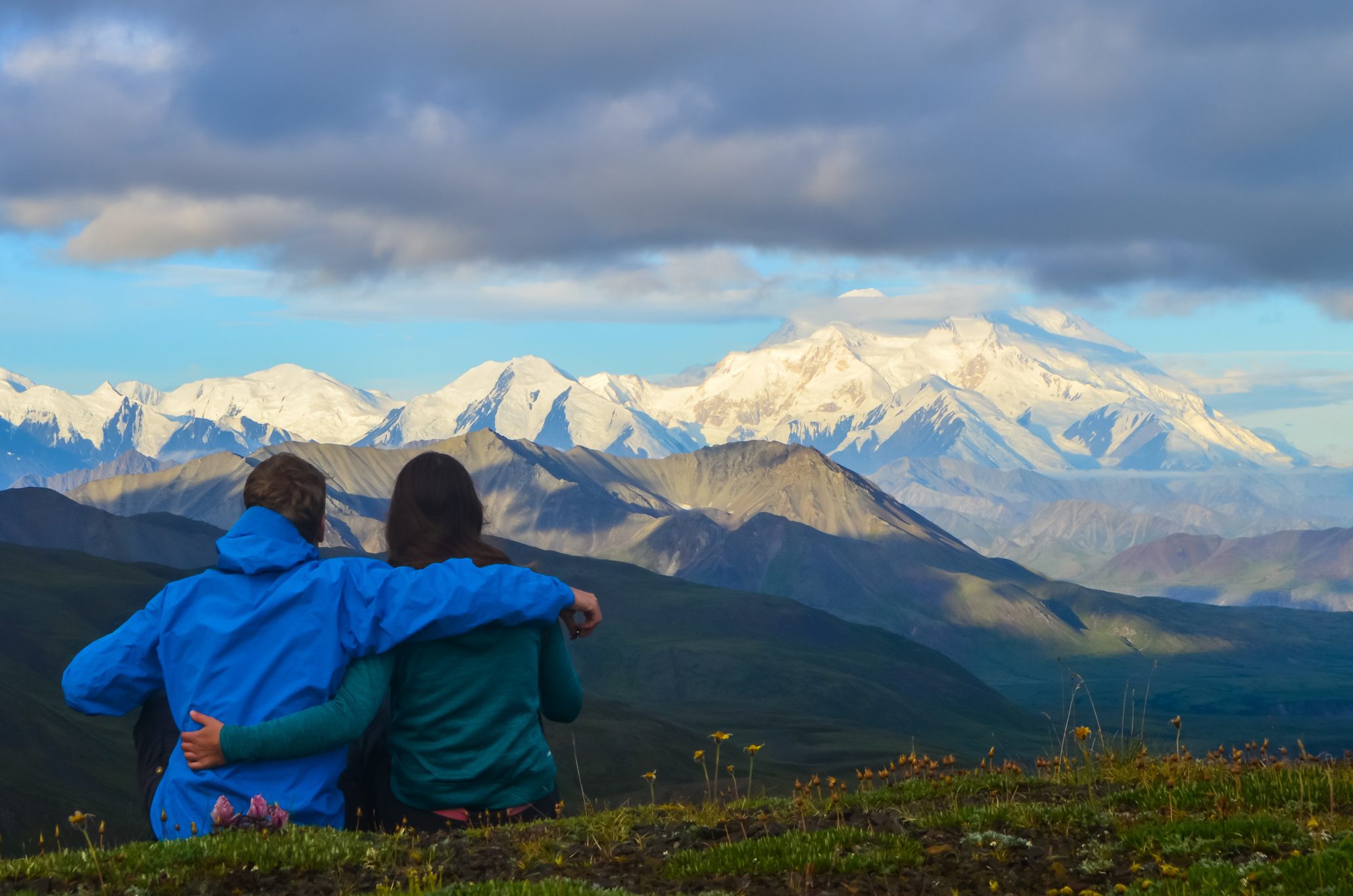 Couple watching a morning view of Mount Denali - mt Mckinley peak during golden hour from Stony Dome overlook in Denali National Park