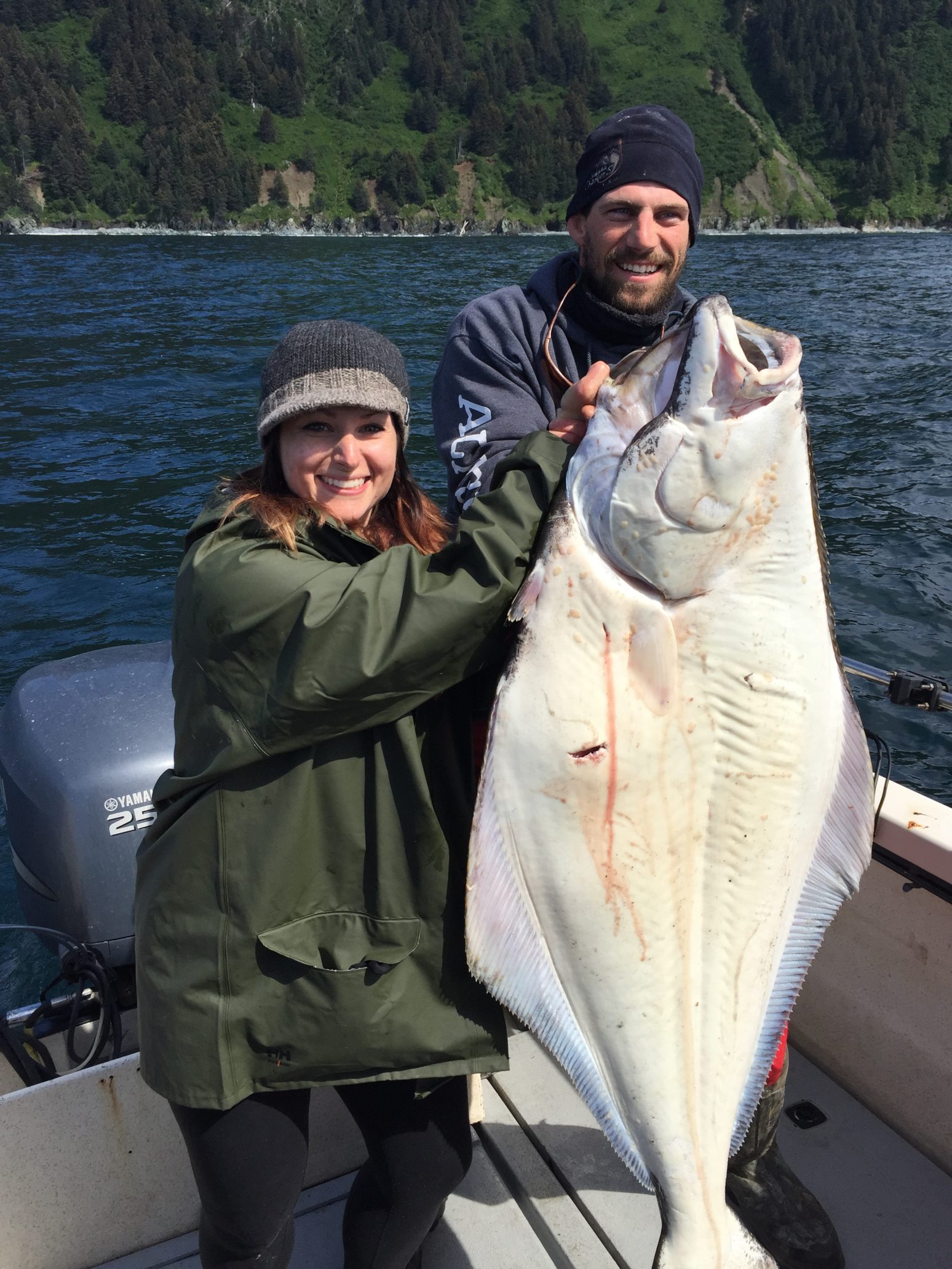 couple holding big alaskan halibut