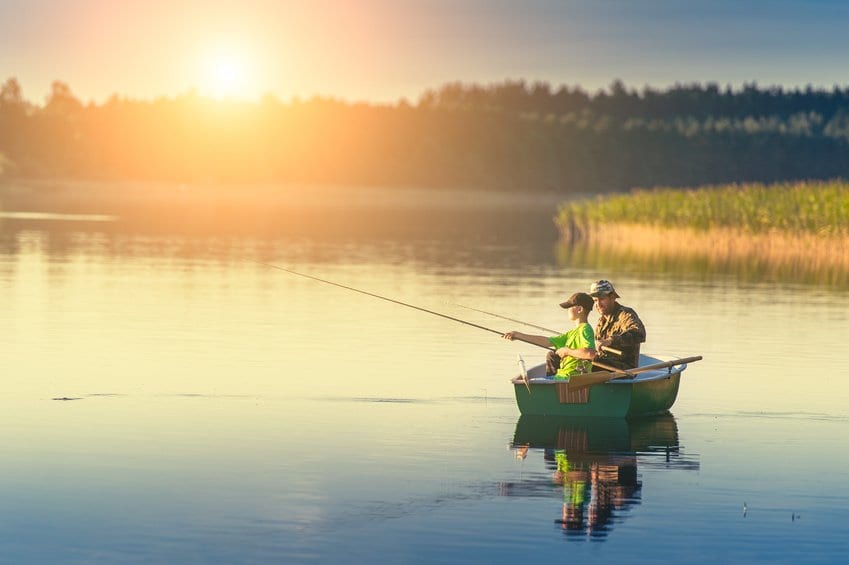 father and son fishing on a boat