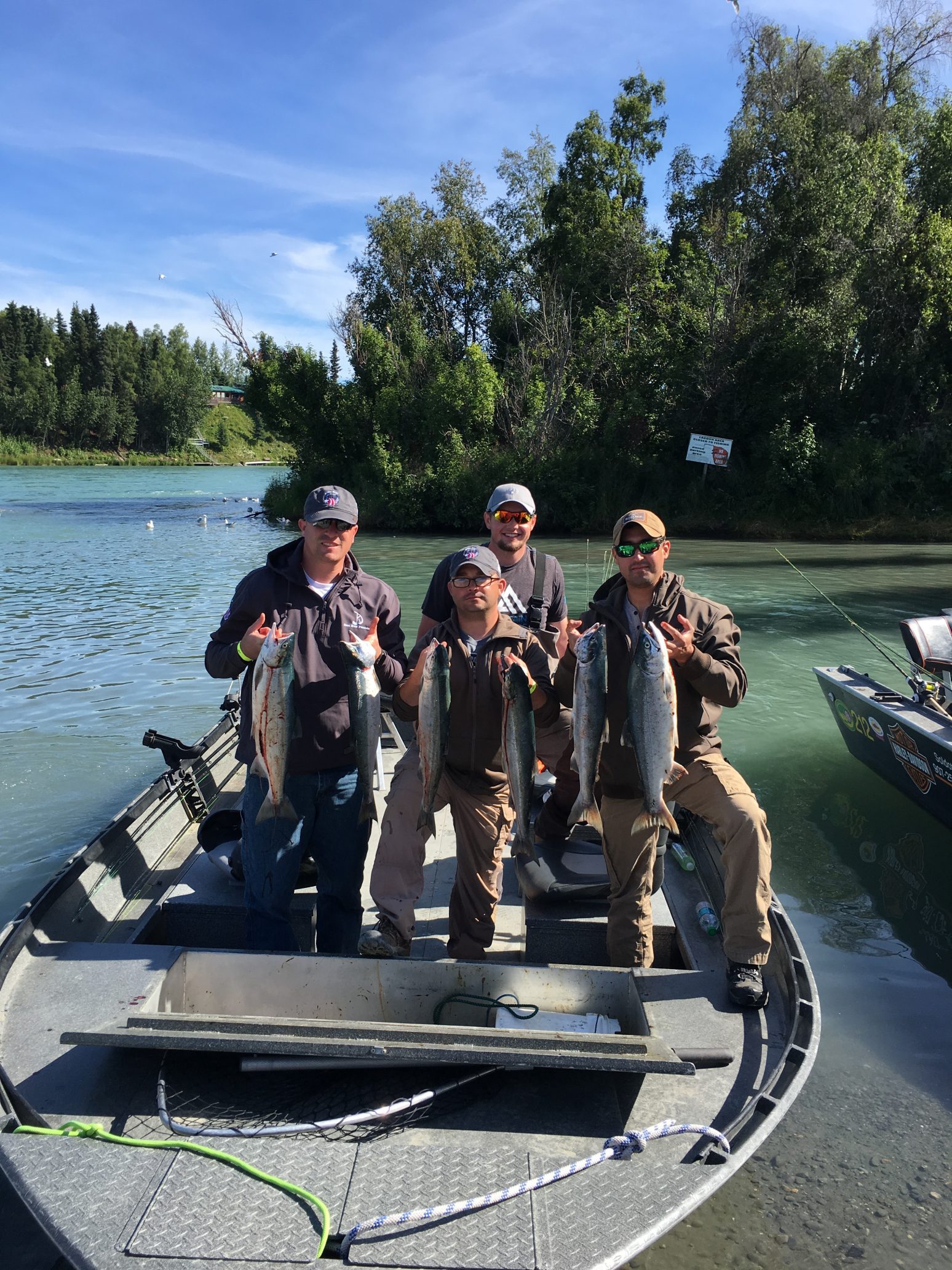 boat-full of men showing off salmon catch in Alaska