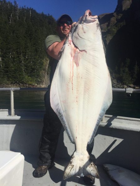 man holding enormous halibut